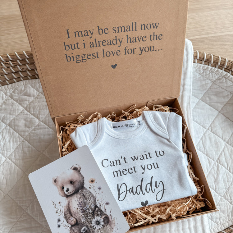 A special idea to tell your husband / boyfriend you're pregnant. Kraft brown magnetic close box, with black serif font written inside box on lid 'I may be small now but i already have the biggest love for you...' inside the box is raffia and a white baby onesie that reads ' Can't wait to meet you Daddy'. The name can be customised to the name of your choice.