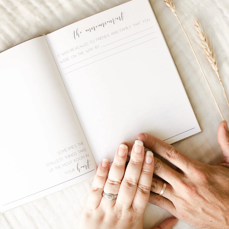 Pregnancy announcement journal. This page features a written prompt all about your baby announcement. It says 'The Announcement. It was revealed to family that you were on the way by...' There is also space to include a photo.