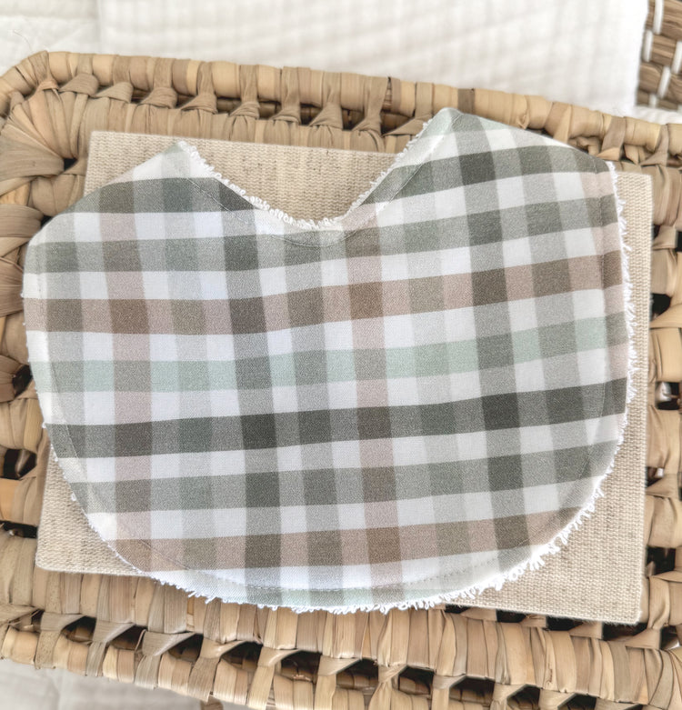 Handmade baby bib with a checkered plaid pattern in moss green, taupe brown, and pale grey on soft cotton, contoured for newborn comfort