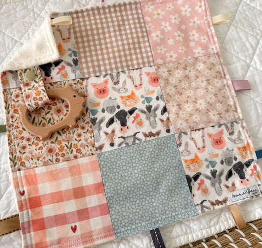 Patchwork mini quilt with various patterns and textures, including floral and farm animal designs.