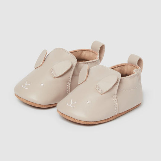 Pair of beige baby shoes with a bunny face.