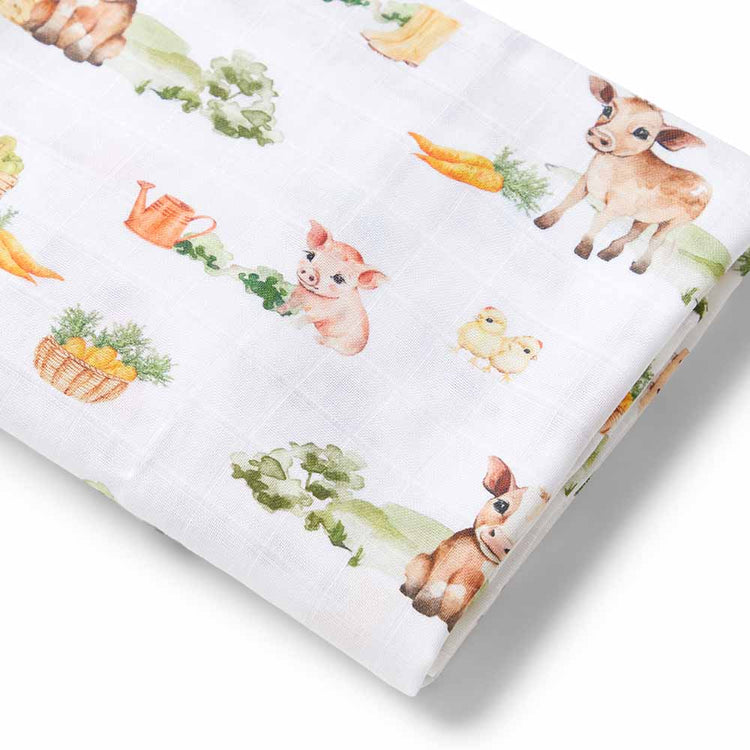 Baby muslin swaddle with farm animal pattern on a white background