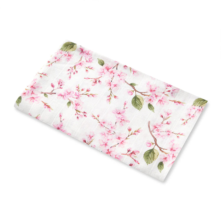 Floral muslin swaddle with pink blossoms and green leaves on a white background