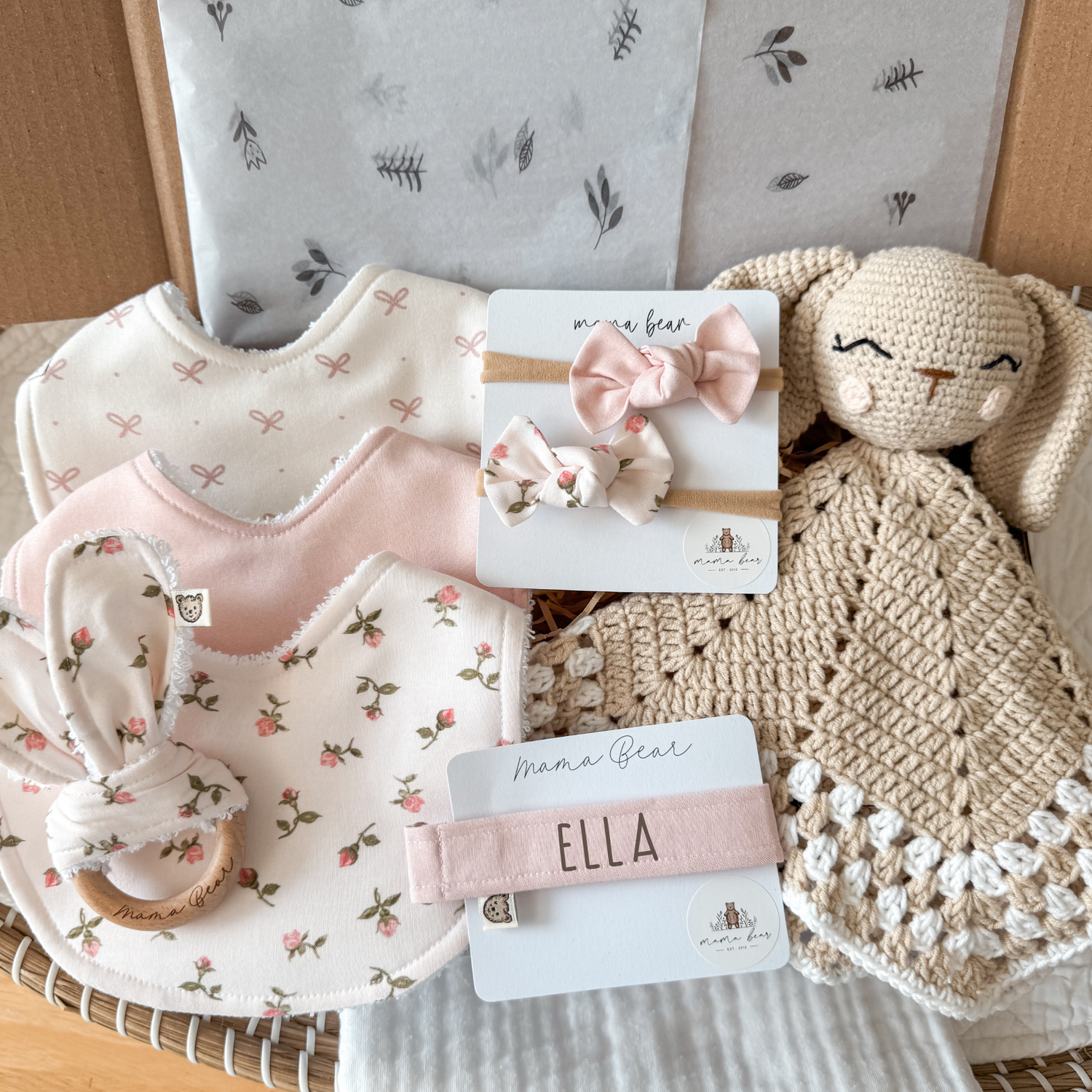 Pink baby girl gift hamper featuring handmade newborn items, including personalised dummy clip, handmade bibs, crochet comforter, baby headbands / hair bows and soft baby bunny comforter. Perfect for baby shower gifts, newborn keepsakes or a thoughtful gift box for new parents. Luxury baby gift set for baby girl.