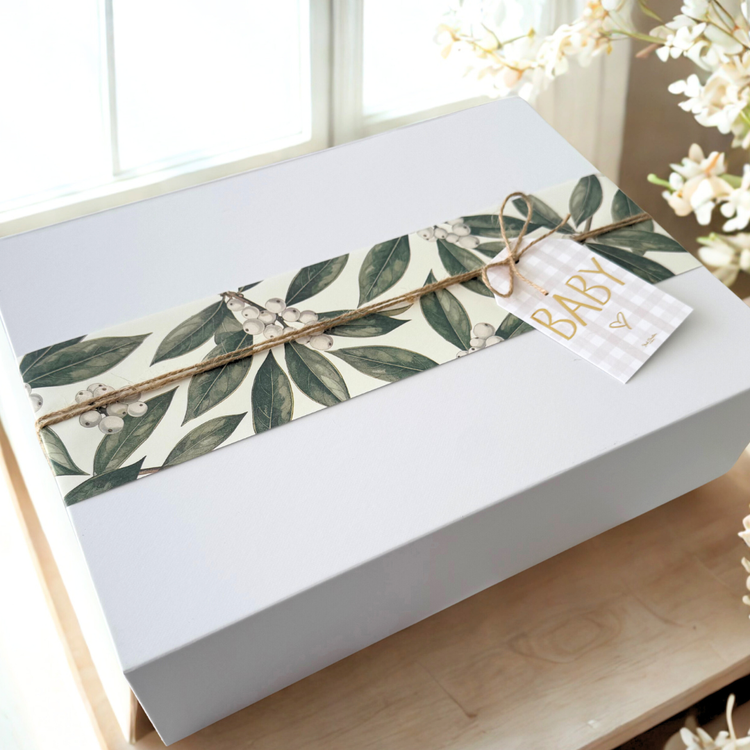 Unisex baby gift box. White magnetic closure gift box with a green leaf wrapping.