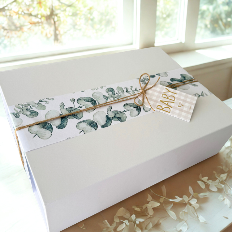 White gift box with a green leaf wrapping and 'baby' gift card.
