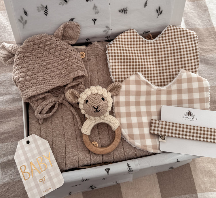 Gender Neutral baby gift box with knitted baby outfit, bonnet, handmade gingham baby bibs, crochet lamb rattle and matching baby dummy chain all in coordinating beige and soft cream tones. 