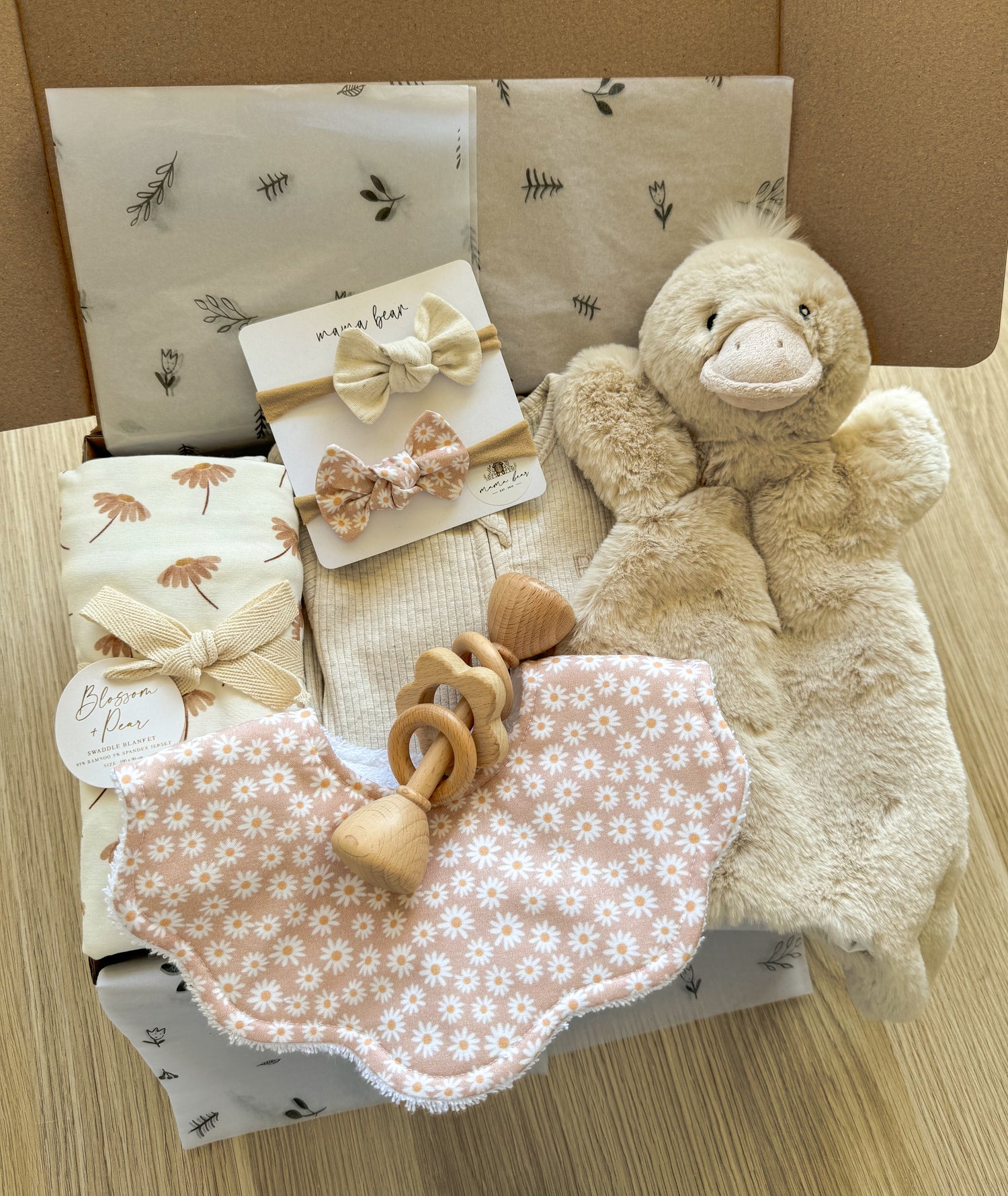 Gift set perfect for baby sprinkle. Features soft duck toy, personalised bib with baby's name, matching hair bows, baby grow suit, floral swaddle & wooden baby rattle - packaged beautifully inside a kraft giftbox