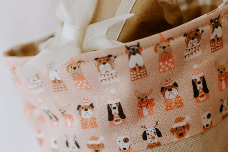 Close-up of pink Christmas stocking cuff featuring festive puppy dog print with different breeds wearing Santa hats and scarves, part of a handmade personalised stocking.