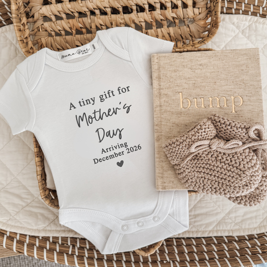 Baby announcement shirt with 'A tiny gift for Mothers day arriving December 2026'. Making a special way to share your pregnancy news with your Mum on Mother's Day.