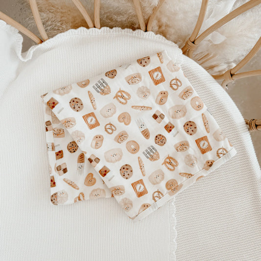 Baby swaddle with cookie pattern on a textured surface