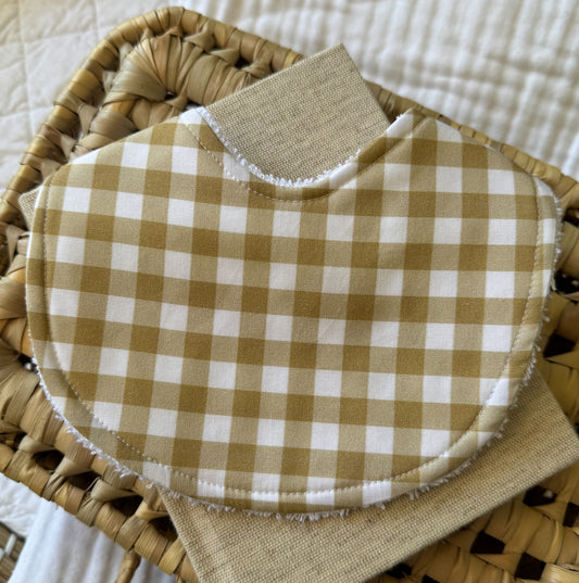 A beige and cream gingham bib.
