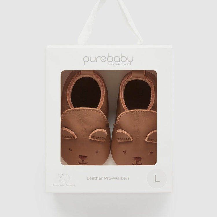 Pair of brown baby leather pre-walkers in packaging with 'purebaby' branding on a white background.