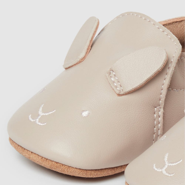 Beige baby shoes with white bunny face.