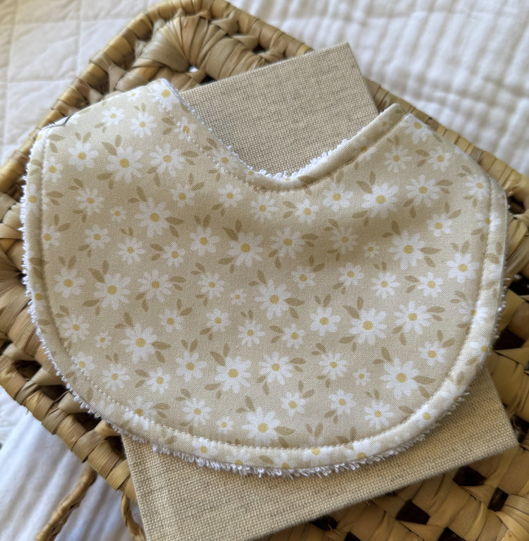 Beige background material with mini pale white daisy illustrations handmade bib