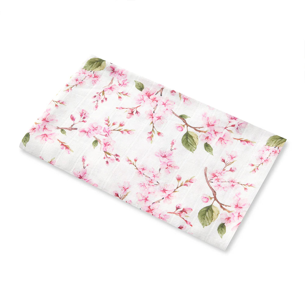 Floral muslin swaddle with pink blossoms and green leaves on a white background