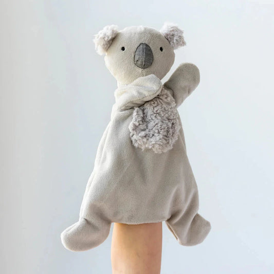 A hand holding a gray plush toy shaped like a koala bear with a soft fabric body, featuring a dummy attachment for comfort.