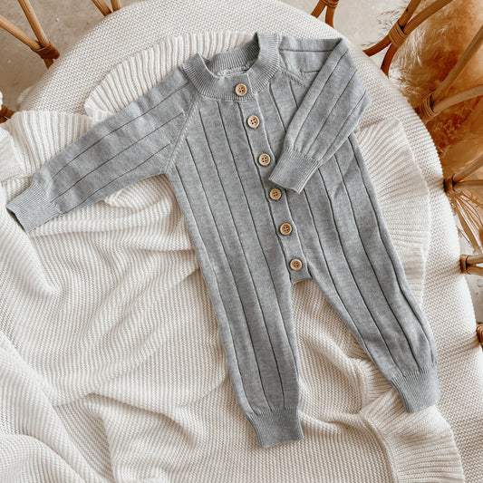 Flaylay of a pale blue knit romper for newborn baby boy.