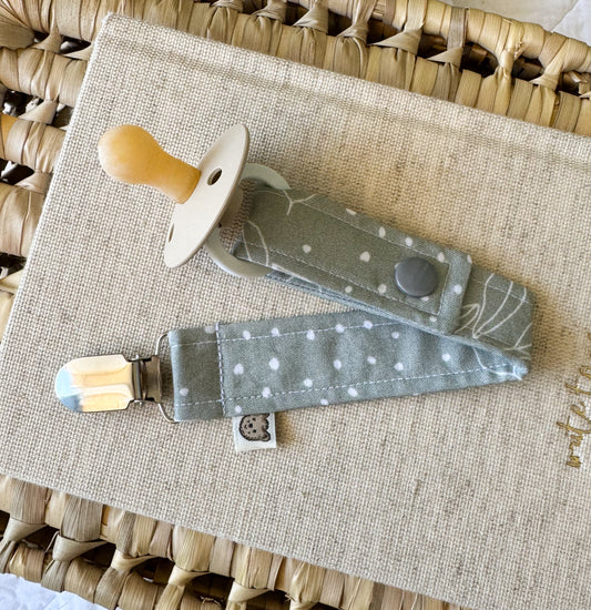 A sage green material dummy clip with white spots and leaves.