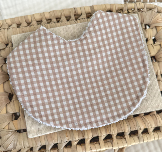 Handmade baby bib with a small check gingham print in warm latte brown and white cotton, contoured for newborn comfort and perfect for gender-neutral gifting.