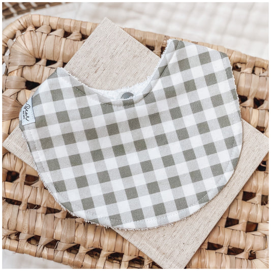 Baby bib with sage green and white gingham check pattern.