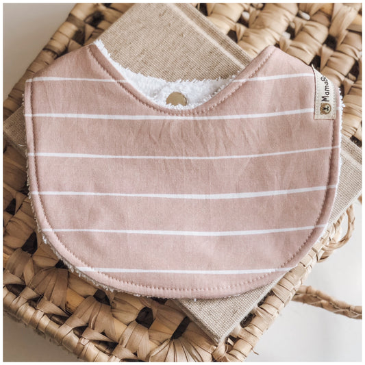 Baby bib in a soft dusty rose pink with thin horizontal white stripes, made from cotton with an absorbent towelling back.